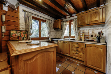 Kitchen of a wooden cabin with rustic country style furniture and dark stoneware floors