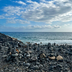 Fototapeta na wymiar Stone figures on a beach with a beautiful sky in Tenerife. Costa Adeje. Balance and serenity