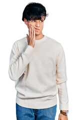 Handsome hipster young man wearing casual winter sweater touching mouth with hand with painful expression because of toothache or dental illness on teeth. dentist