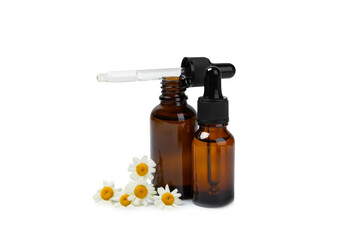 Glass bottle with chamomile essential oil isolated on white background. Chamomile flowers, close up. Aromatherapy, spa and herbal medicine ingredients. Beauty concept. Natural cosmetics
