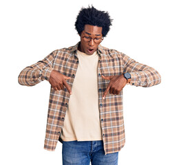 Handsome african american man with afro hair wearing casual clothes and glasses pointing down with fingers showing advertisement, surprised face and open mouth