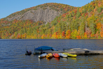 Fototapeta na wymiar Colorful kayaks docked at a lake in the mountains in Autumn
