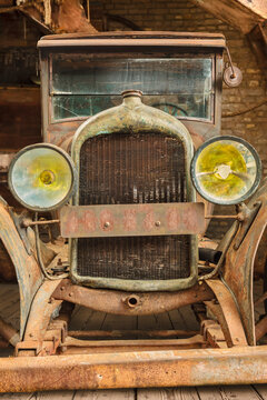 Retro styled image of an early twentieth century rusted and broken classic car