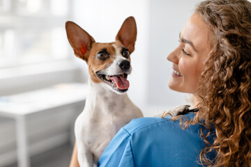 Vet with joyful dog close-up in clinic