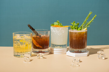 Alcoholic cocktails with ice on podiums on colored backgrounds