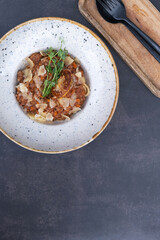 Bolognese in a bowl on a dark background top view, flat lay with copy space
