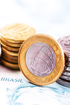 details of banknotes of 100 reais from brazil, and brazilian coins, with selective focus, background image. Concept of investment in brazil or profit.
