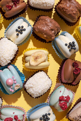 Set of different macaroons on yellow background top view, flat lay