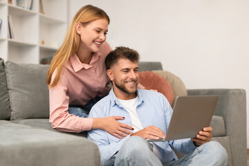 couple browsing websites and watching movies on laptop at home