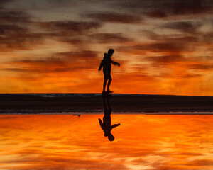 silhueta de homem em nascer do sol na Praia do Cassino, em Rio grande, Rio Grande do Sul - obrazy, fototapety, plakaty