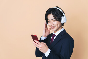 ヘッドホンとスマホで音楽を聴く男性