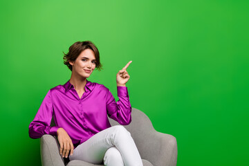 Portrait of young charming confident business woman in pink shirt point finger empty space commerce deal isolated on green color background