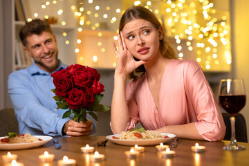 Woman skeptical of man's roses at dinner