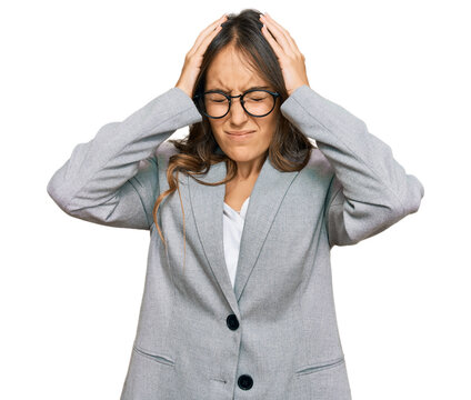 Young brunette woman wearing business clothes suffering from headache desperate and stressed because pain and migraine. hands on head.