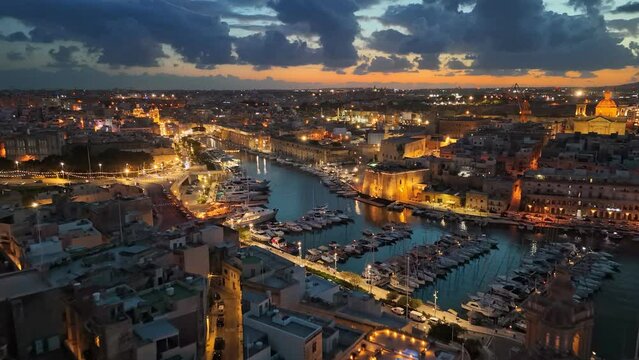 Aerial sunset view of three cities - Vittoriosa, Senglea and Cospicua - Malta. Epic evening shot of old town with churches and marina with yacht in Malta