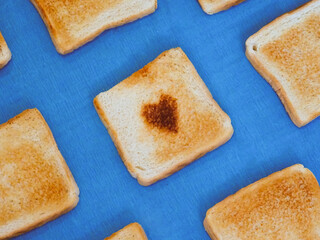 Pieces of toast with toasted hearts on a blue background
