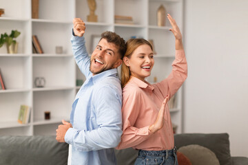 Fototapeta premium Millennial couple dancing together in living room at home