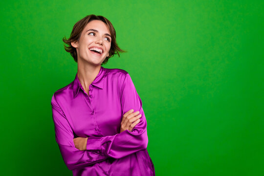 Portrait of nice positive minded lady folded arms look empty space shiny magenta shirt isolated on green color background