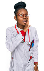 Young african american woman wearing doctor uniform and stethoscope hand on mouth telling secret rumor, whispering malicious talk conversation