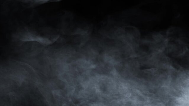 Atmospheric smoke 4K Fog effect. VFX Element. Haze background. Abstract smoke cloud. Smoke in slow motion on black background. White smoke slowly floating through space against black