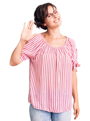 Fototapeta na wymiar Beautiful young woman with short hair wearing casual summer clothes waiving saying hello happy and smiling, friendly welcome gesture