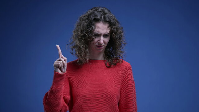 Baffled woman reacting to accusation with surprise, pointing finger to herself rejecting recrimination - waving finger "not me" body language