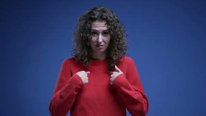 Baffled woman reacting to accusation with surprise, pointing finger to herself rejecting...
