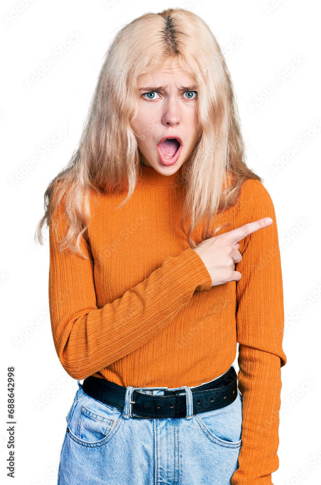 Canvas Prints Young caucasian woman wearing casual clothes surprised pointing with finger to the side, open mouth amazed expression.