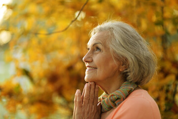 Naklejka premium Senior woman walking in the park in autumn. 
