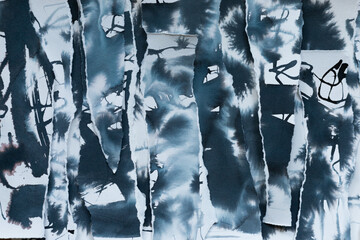 Abstract grunge black, navy blue and white backdrop with scraps of paper and black navy blue ink paint spots. Torn paper texture and painting stains background.	