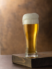 Glass of light beer on a dark wooden background