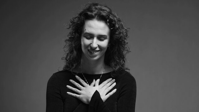 Heartfelt Moment Of Woman Putting Hands On Chest Feeling Thankful And Sincere Gratitude In Black And White, Monochrome