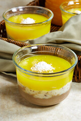 Homemade layered vegan dessert of baked coconut cream and chocolate in basket with milk bottle