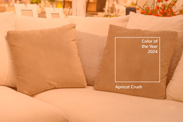 Close up light fabric sofa with warm cozy cushions with home interior background. Image toned in trendy color of year 2024 Apricot Crush. Orange pillow on sofa room decoration background - obrazy, fototapety, plakaty