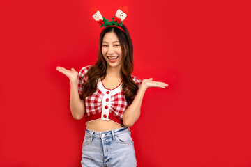 Young asianwoman wears green clothes Santa hat hold open shopping package bags isolated on  red...