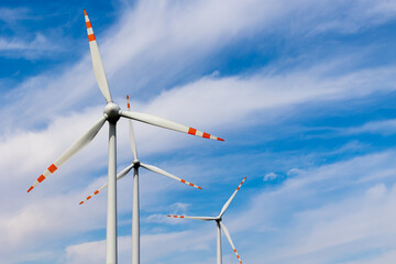 Wind turbine rotors against the blue sky. Green electricity production. Photo taken on a sunny day.