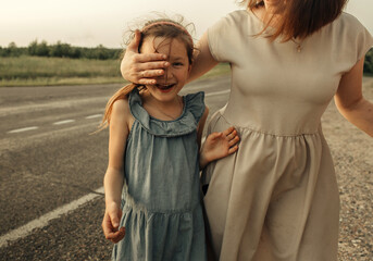 Mom closed her daughters eyes, her daughter smiles.