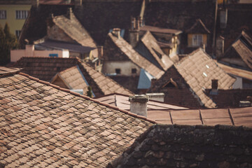 Scenic view of traditional romanian tile roofs of houses in the Old Town of Sighisoara. old town roofs with cimneys. View of the town from the hill. 