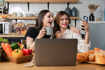 Two successful businesswomen express joy while working together at their home office. Share your...