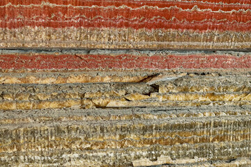 A wall in a salt mine. The soil layers of the earth. Red salt.