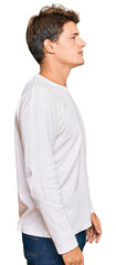 Handsome caucasian man wearing casual white sweater looking to side, relax profile pose with natural face and confident smile.