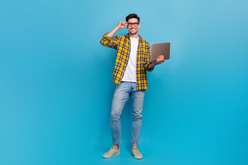 Full size body photo of smart young guy programmer touch eyeglasses hold netbook fixing bugs in...