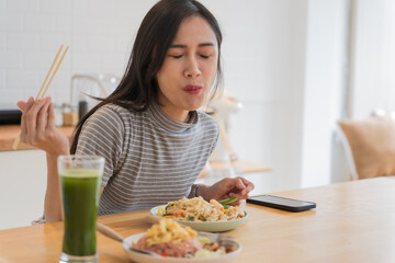 Asian Girl  eating Thai food in kitchen counter Home delivery food feeling happy 