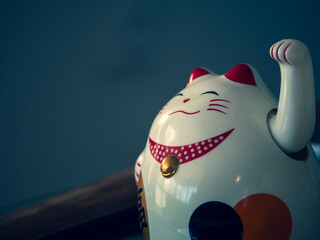 Vieille statue traditionnelle japonaise en céramique et poussiéreuse d'un chat porte-bonheur