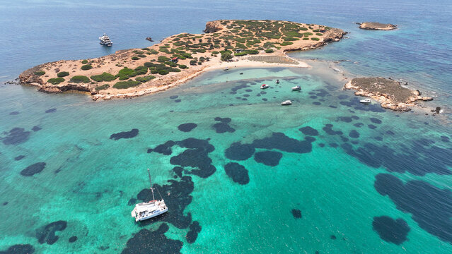 Aerial drone photo of famous small uninhabited island of Ydrousa or Katramonisi with crystal clear emerald sea perfect of yacht anchorage, Voula, Athens Riviera, Attica, Greece