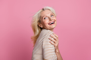 Photo of adorable cheeful glad lady dressed trendy clothes looking empty space banner isolated on pink color background