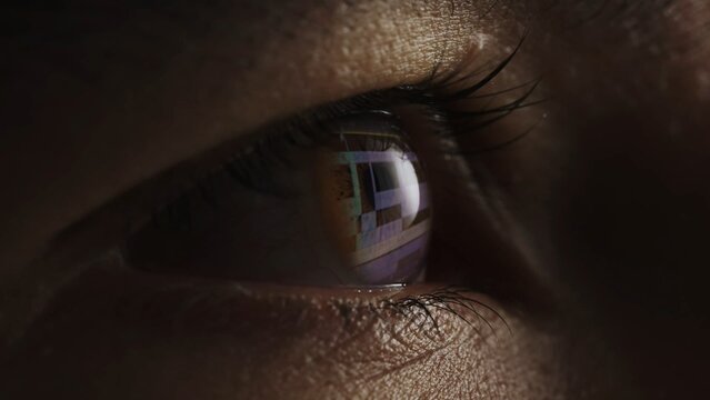 Macro shot of eyes with program for video editing reflection. Video processing, postproduction, clip maker.