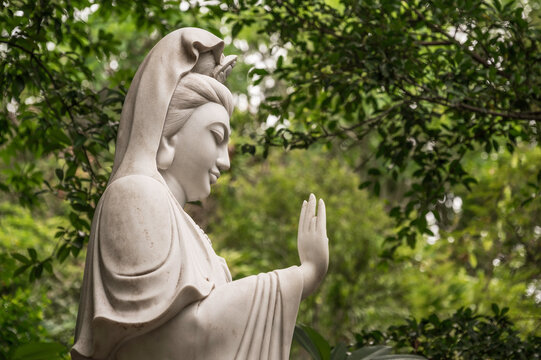 Marble statue of the Ladt Bhuddah, against an out of focus jungle bagle background. The statue is located at the Marble Mountains, Vietnam