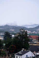 Fototapeta premium View on roofs in the city of Dalat. Da Lat and the surrounding area is a popular tourist destination of Asia. City with fogs and mountains