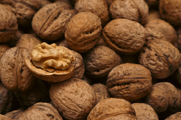 Walnuts in a shell. Background with many walnuts. Ripe walnut sold in the market